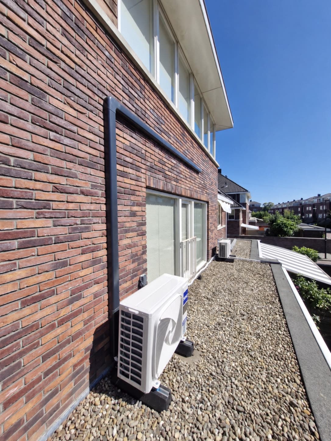 Buitenunit van een airco-installatie op een plat dak